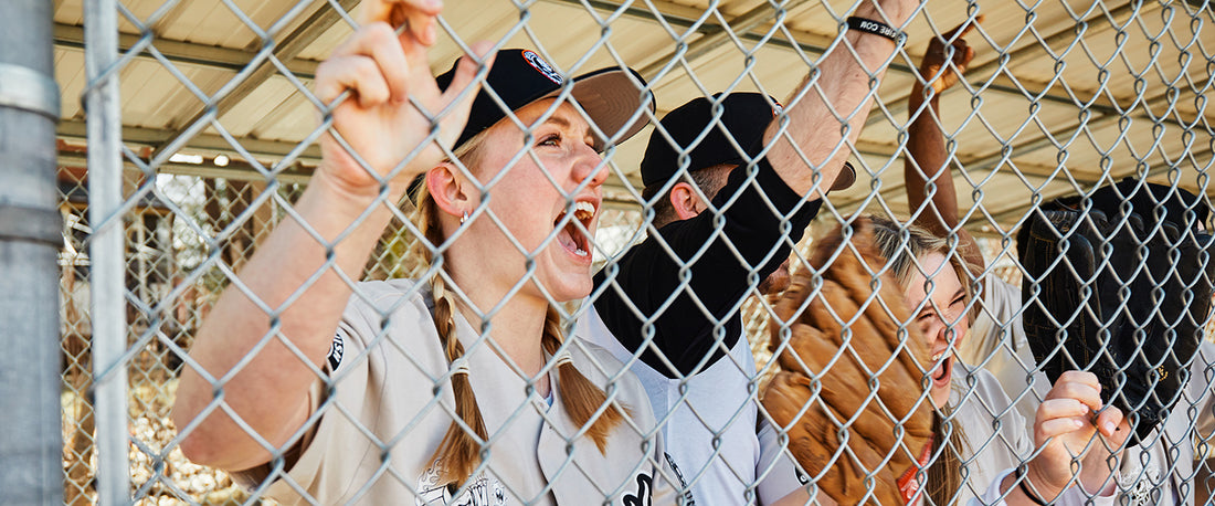 Baseball players cheering on their team from the dugout.