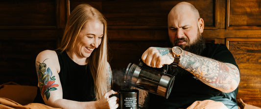 A man and woman pouring a cup of coffee in bed to test the hidden benefits.