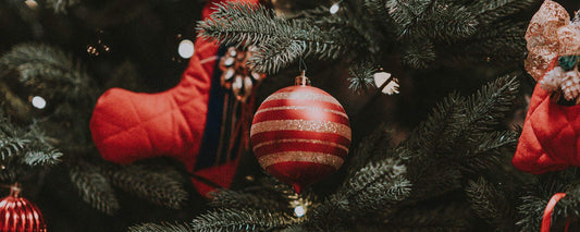 A Christmas tree decorated with red ornaments and white lights.