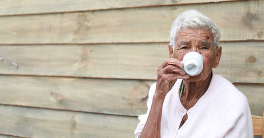 An older man drinking coffee out of a mug.