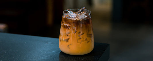 A stemless wine glass with a cold brew coffee cocktail and ice in it. Photo Credit: Pariwat Pannium via Unsplash.