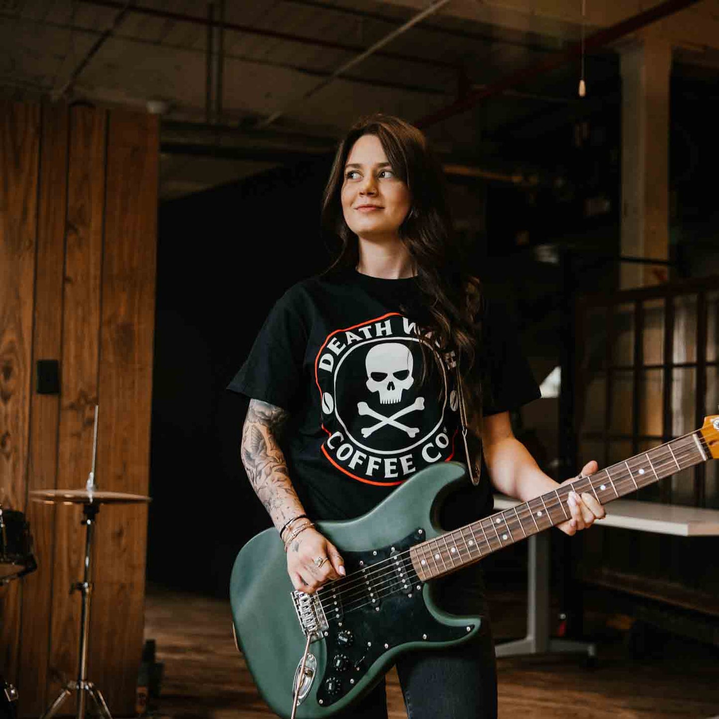 A band member playing guitar in the Death Wish Coffee Core Classic Logo Tee.