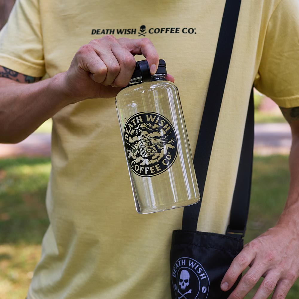 Holding the Death Wish Coffee Higher Ground Water Bottle.