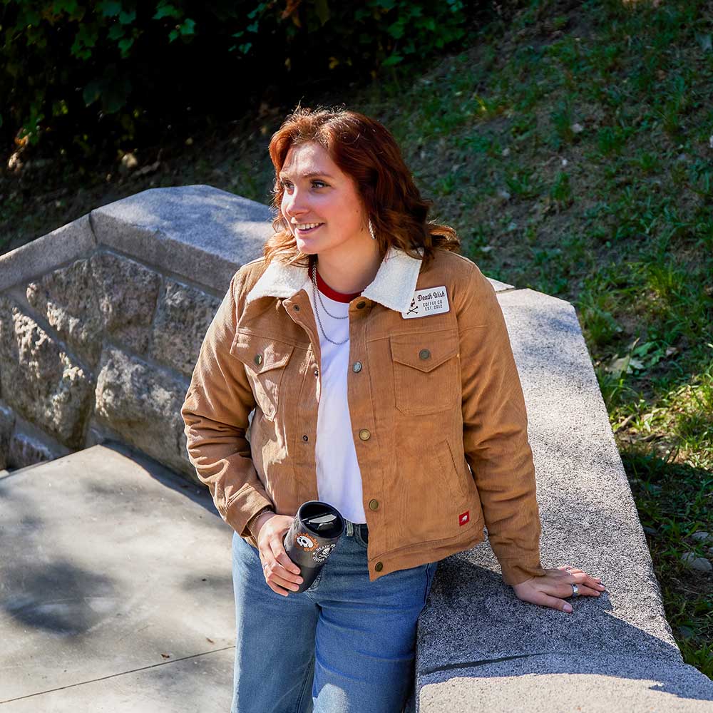 A model wearing the Death Wish Coffee Daily Grind Women's Corduroy Workwear Jacket.
