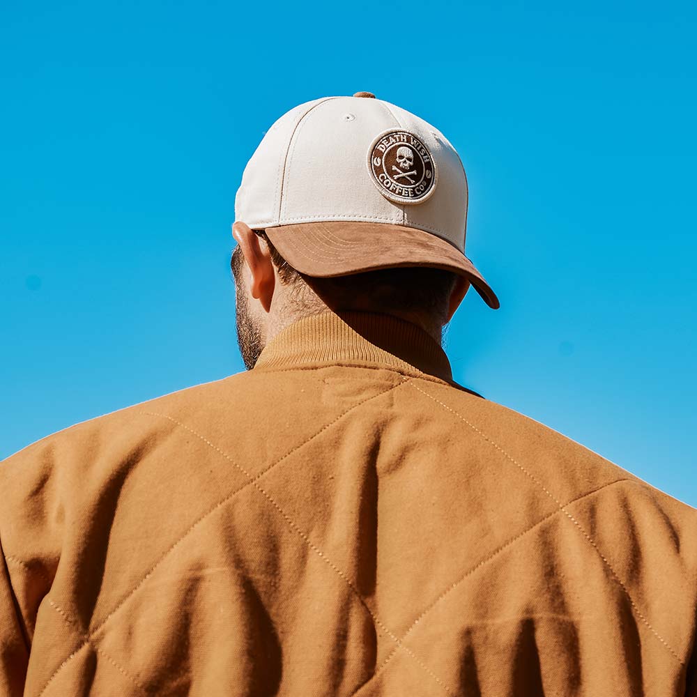 A model wearing the Death Wish Coffee Cream and Coffee Snapback.