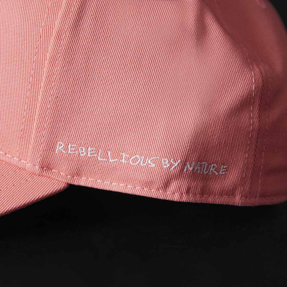 A close up of the Rebellious by Nature embroidery on the Death Wish Coffee Pink Rebellious By Nature Snapback.