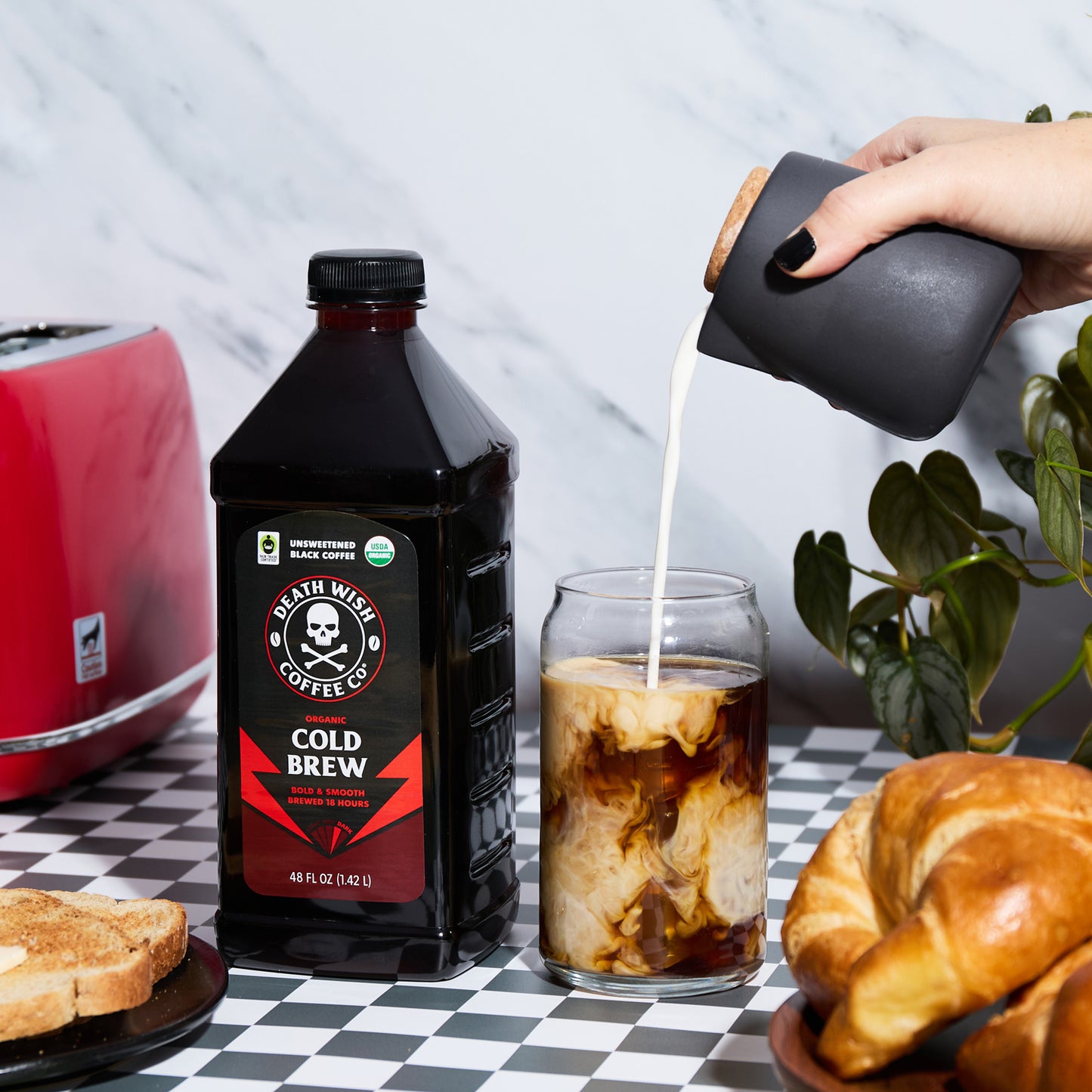 Pouring cream into Unsweetened Death Wish Coffee Organic Cold Brew Coffee.