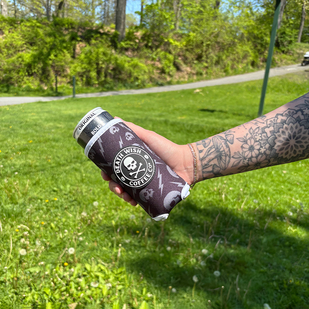 A hand holding the Death Wish Coffee Original Slim Can Koozie.
