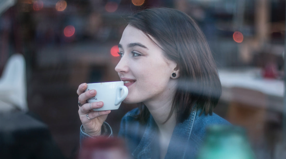 A woman taking a sip of coffee