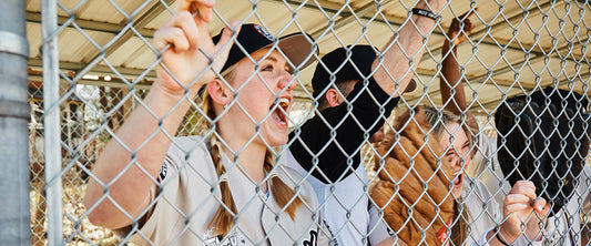 Baseball players cheering on their team from the dugout.