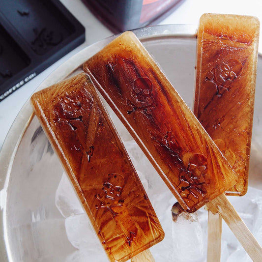A bucket of ice with three iced coffee popsicles