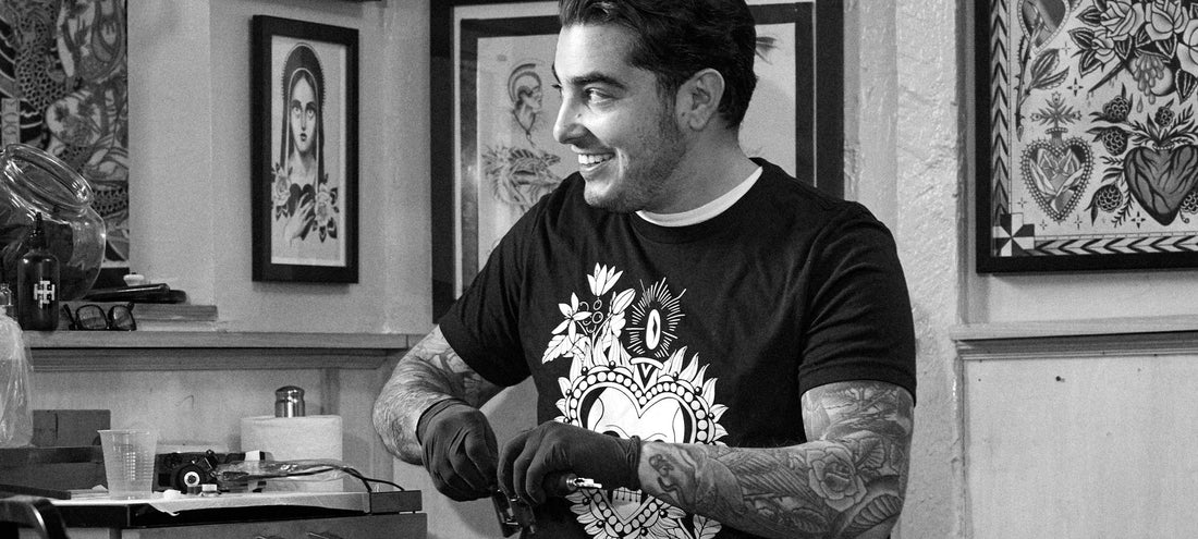 Derick Montez, a tattoo artist working in a tattoo shop wearing a black and white Death Wish Coffee tee.