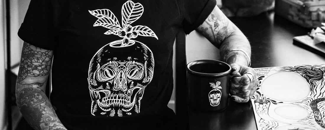 A black and white tee featuring a skull with a coffee plant growing out of the head.