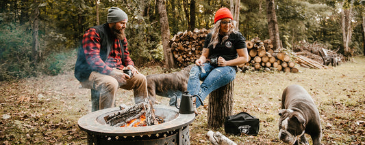 A couple sitting around a campfire making cowboy coffee with Death Wish Coffee.