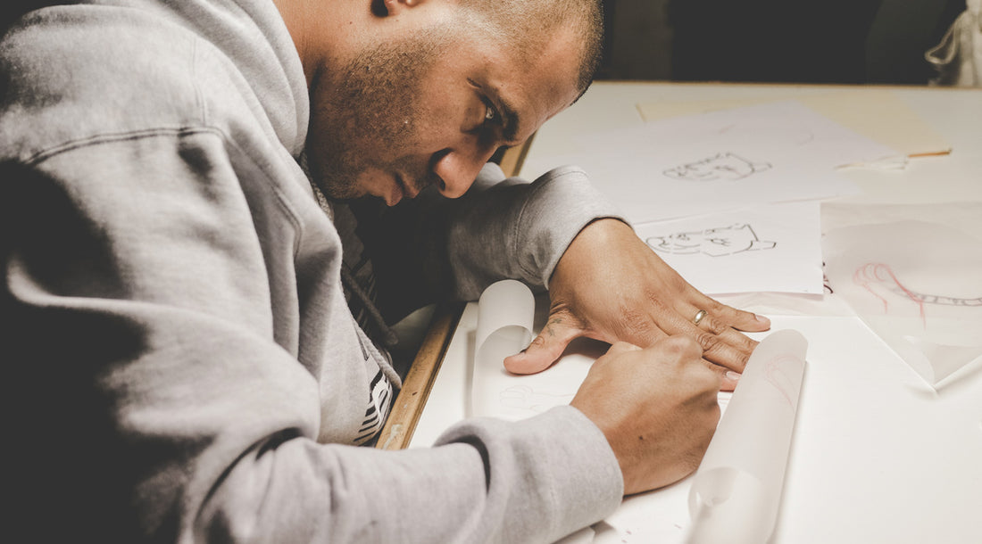 Peter Clarke of Dead Presidents Lounge drawing tattoos by hand.