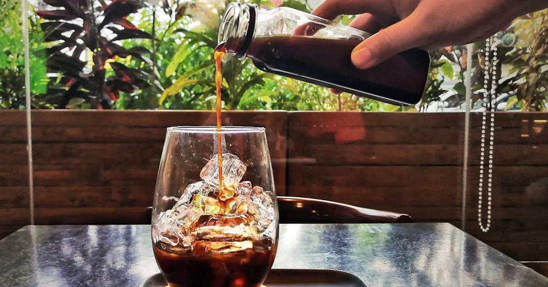 Pouring coffee over ice to make iced coffee.