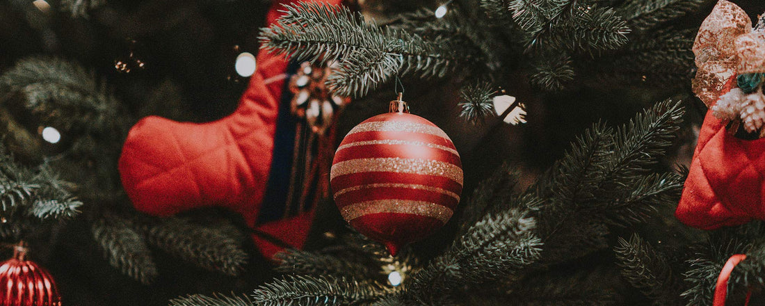 A Christmas tree decorated with red ornaments and white lights.