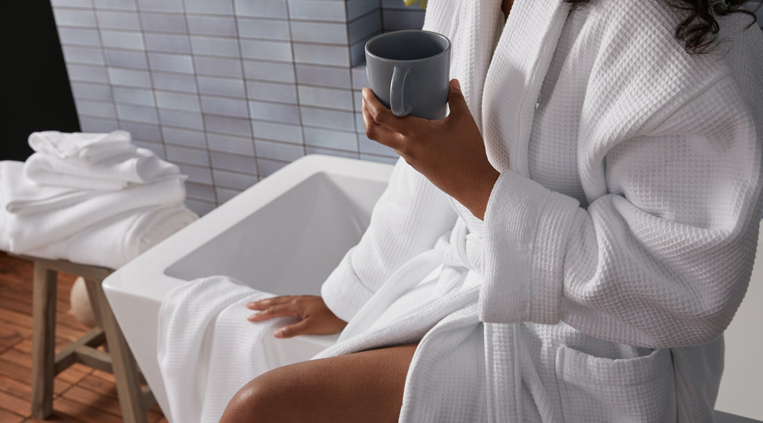 An image of a woman in a bathtub with a coffee facial on her face.
