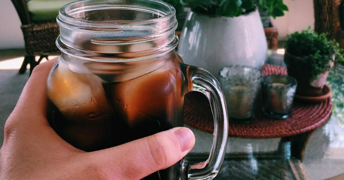 Person holding an iced cup of cold brew coffee
