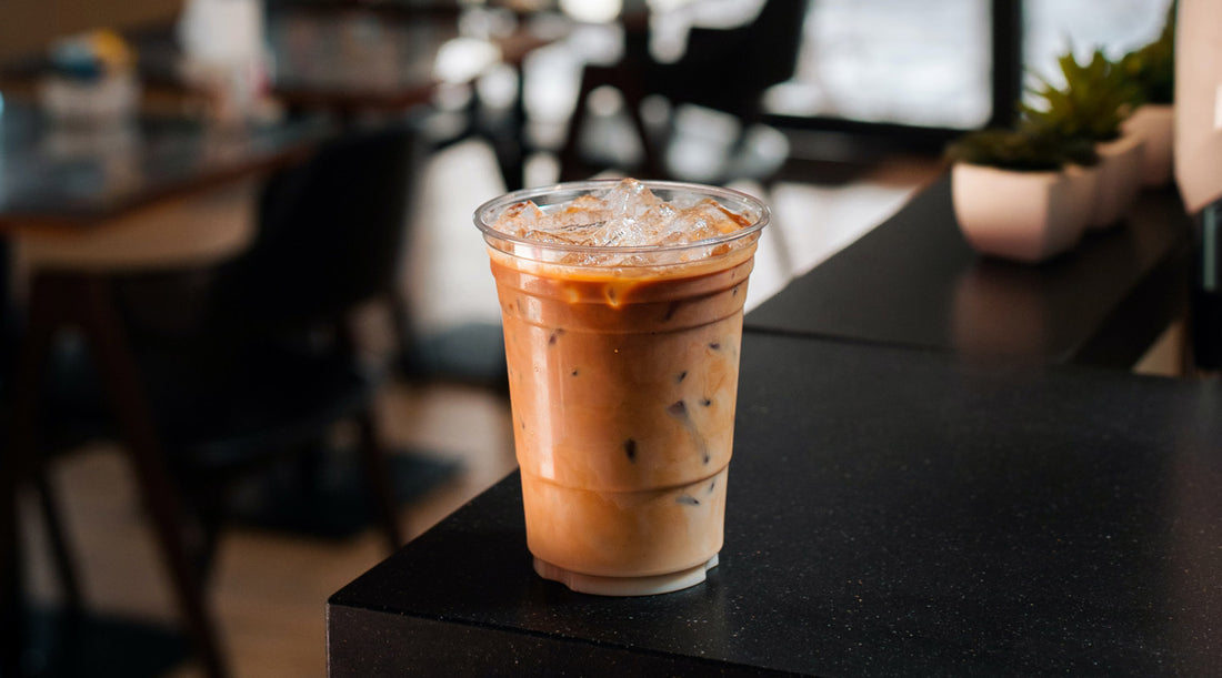 Iced coffee sitting on a counter in a coffee shop.