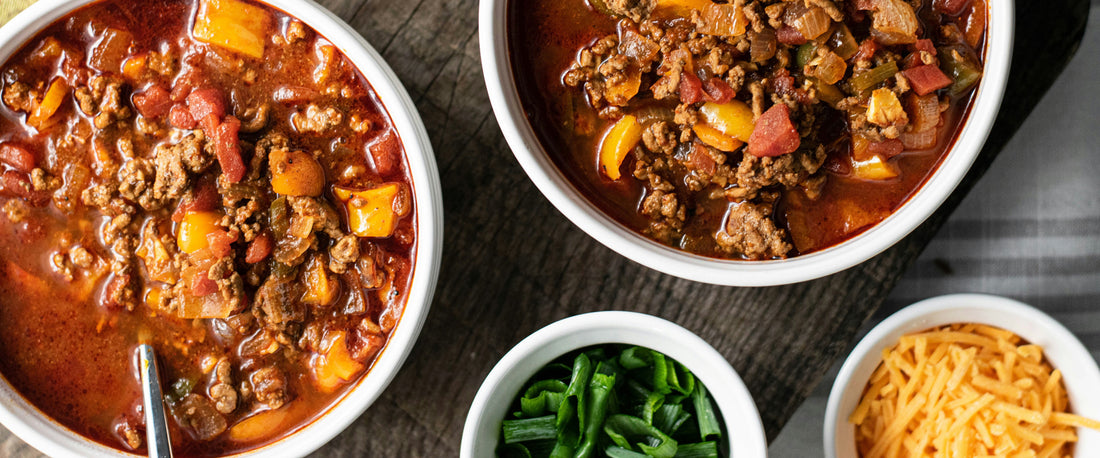 Bowls of chili and the ingredients used to make it.