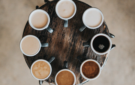 Multiple cups of coffee in a circle on a wooden table