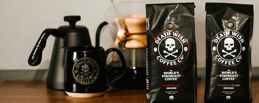 A stovetop kettle, a Chemex, a black Death Wish Coffee mug and a bag of OG Dark Roast and Medium Roast Coffee.