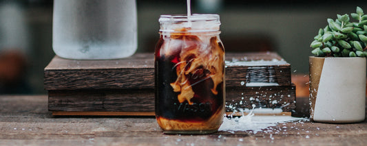 A mason jar with keto-friendly bulletproof cold brew and a plant-based creamer. Photo Credit: Tyler Nix via Unsplash.