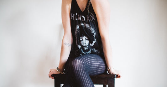 A model sitting in a chair wearing a Jimi Hendrix shirt.