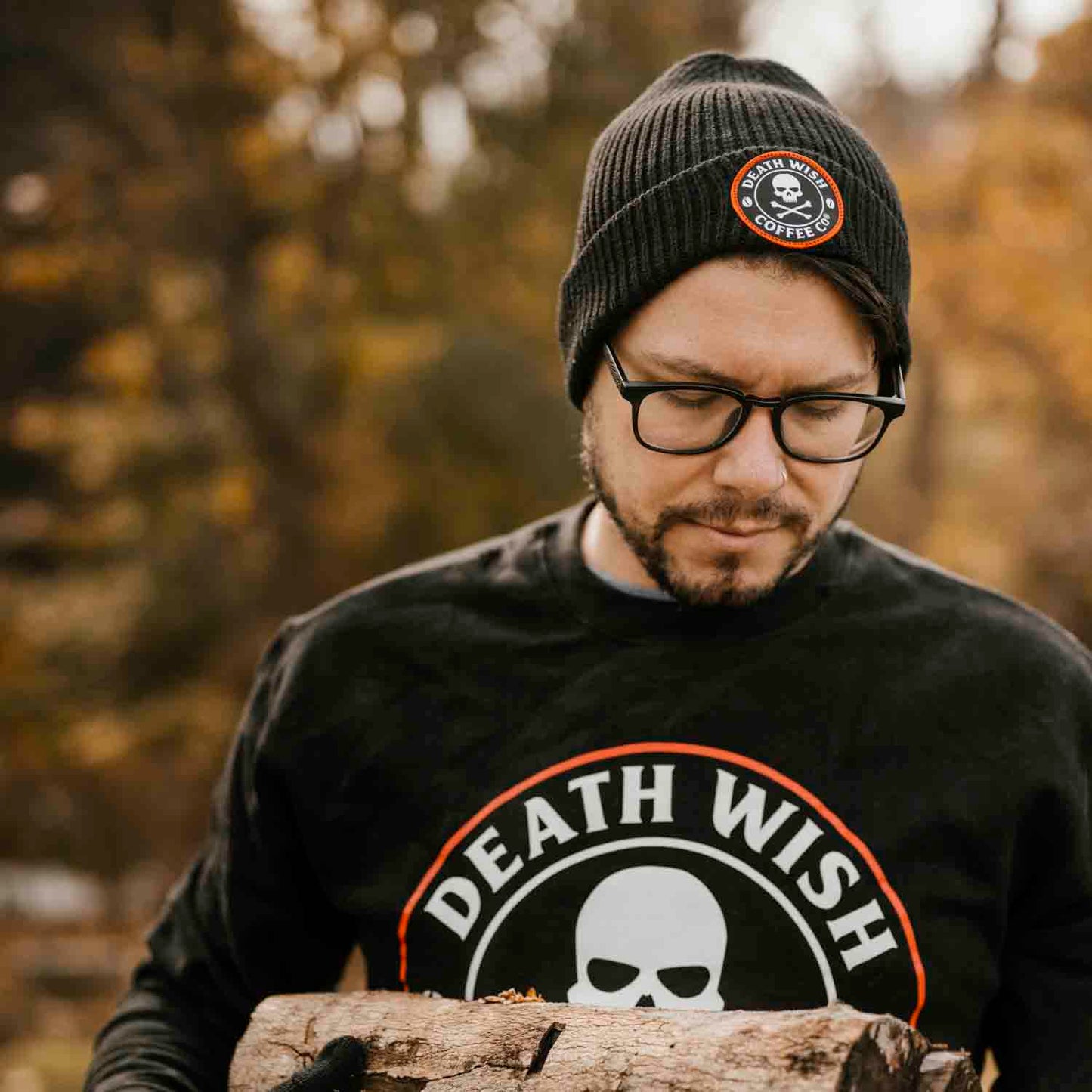 Gathering firewood wearing the Death Wish Coffee Classic Beanie.