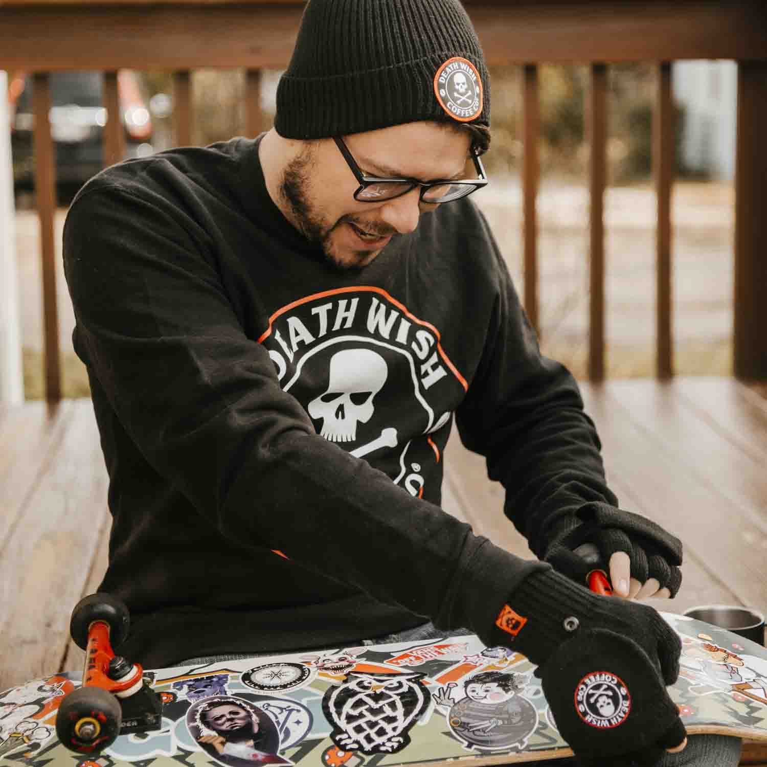 Tuning a skateboard while wearing the Death Wish Coffee Classic Beanie.