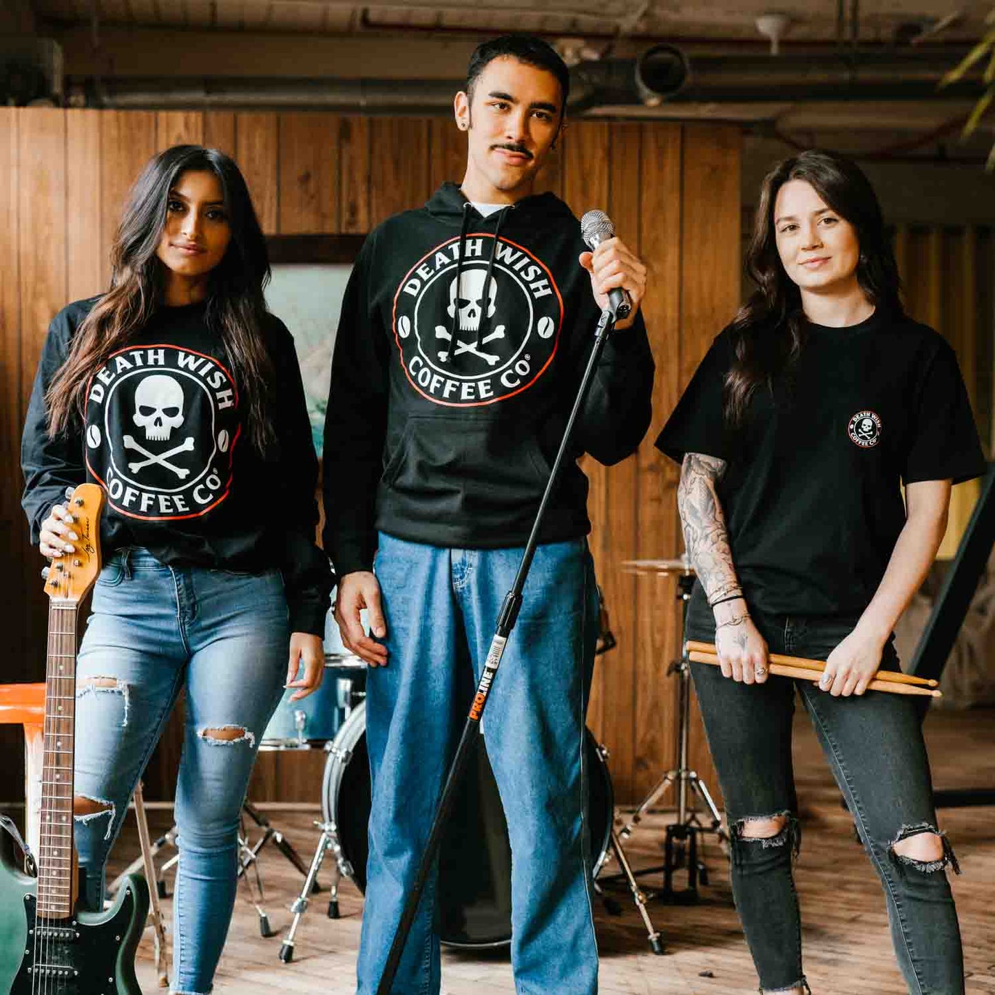 A group photo of the band with one member wearing the Death Wish Coffee Classic Pocket Tee.