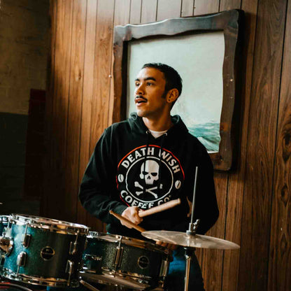 Playing the drums in the Death Wish Coffee Classic Logo Hoodie.