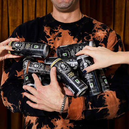 A model holding a hand full of Death Wish Coffee latte cans.