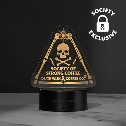The Death Wish Coffee Neon Necromancer LED Light lit up using the Society of Strong Coffee acrylic insert.