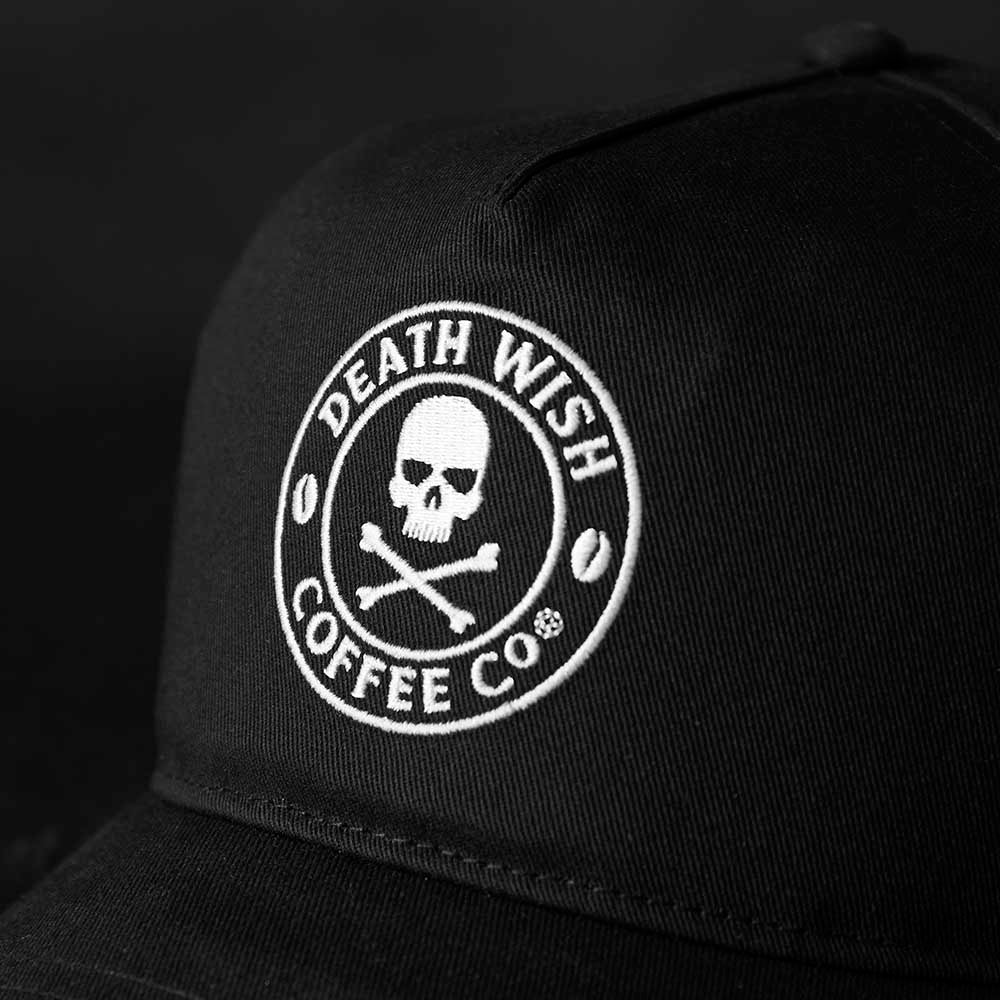 A close up of the front logo of the Death Wish Coffee Black Rebellious By Nature Snapback.