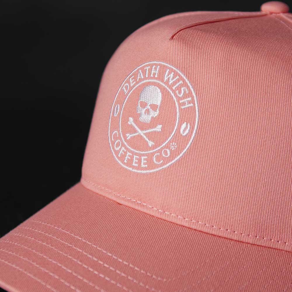 A close up of the front logo of the Death Wish Coffee Pink Rebellious By Nature Snapback.