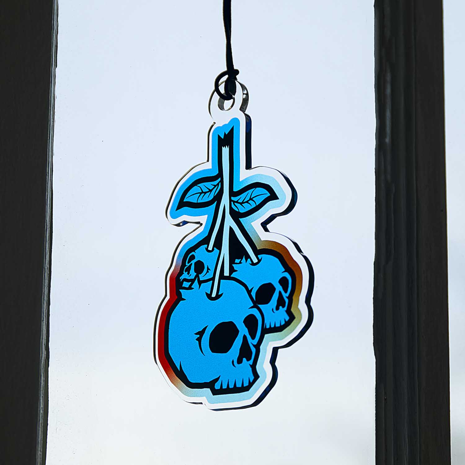 The Death Wish Coffee Blueberry Bliss Suncatcher hanging in a window.