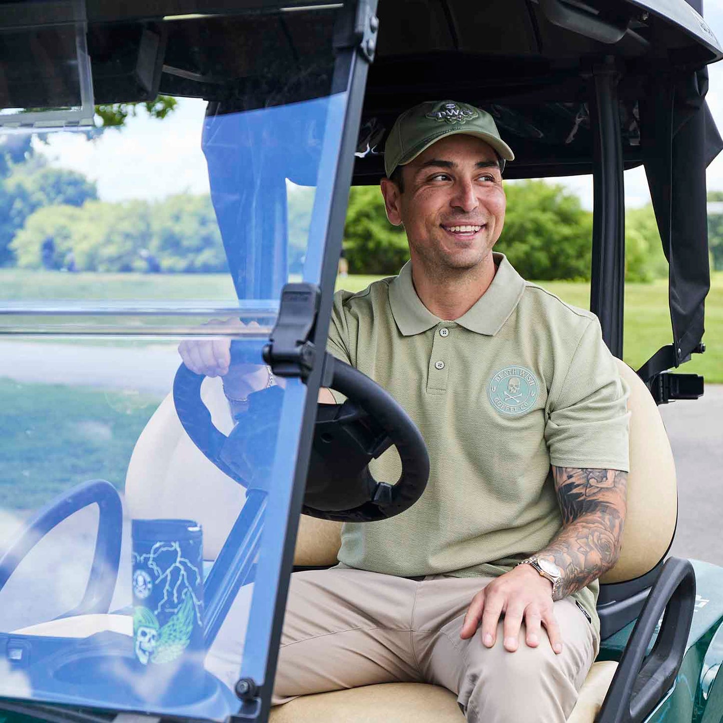 Driving a golf cart wearing the Death Wish Coffee Par For The Course Polo.