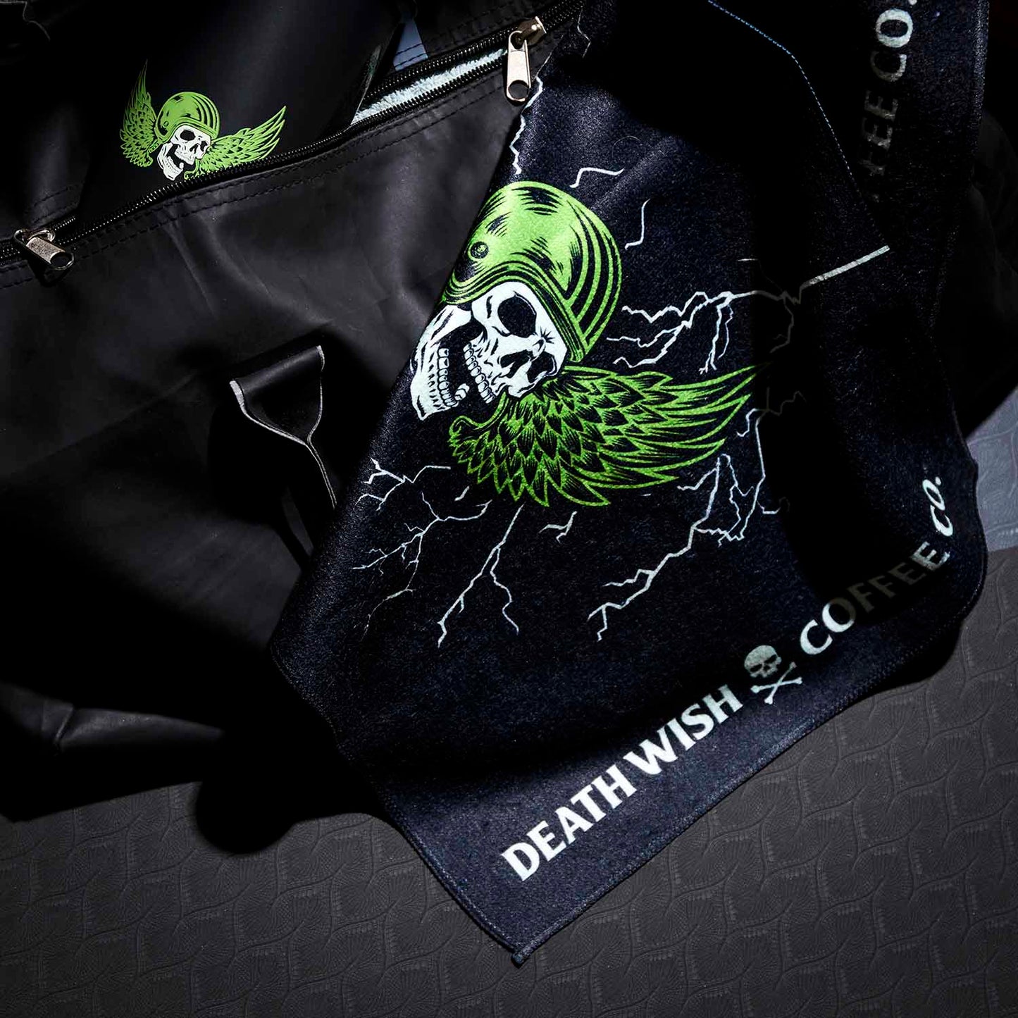 The Death Wish Coffee Blood, Sweat And Coffee Gym Towel hanging out of a gym bag.