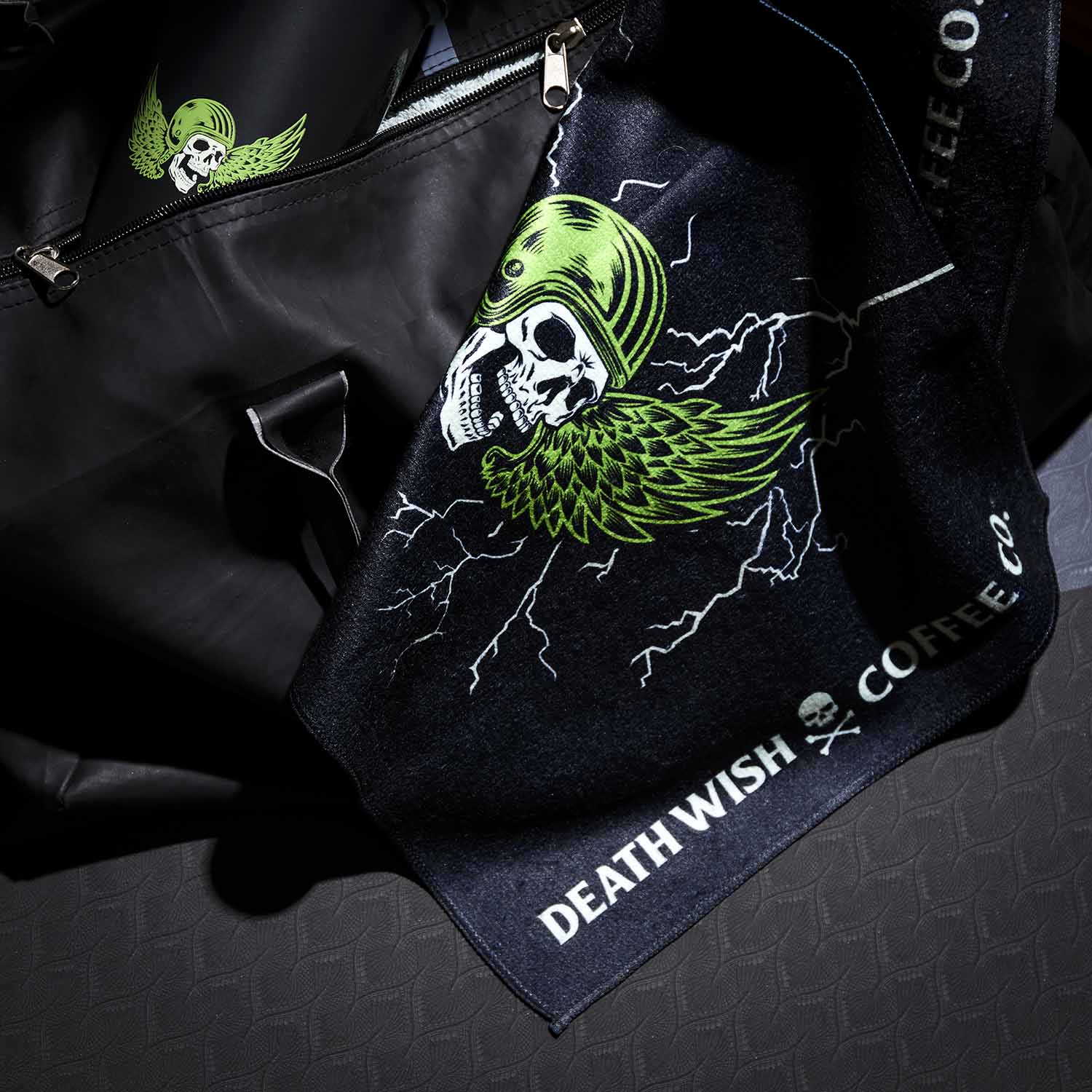 The Death Wish Coffee Blood, Sweat And Coffee Gym Towel hanging out of a gym bag.
