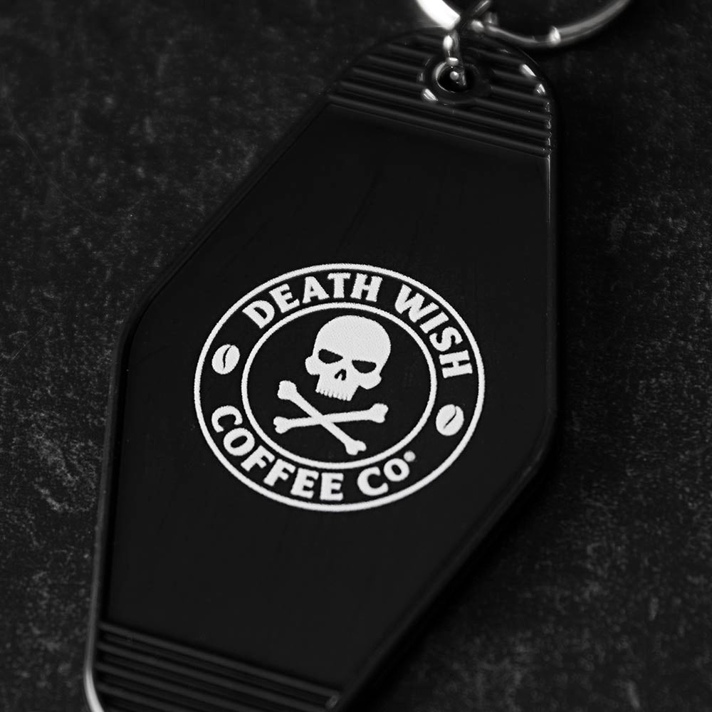 A close up of the back of the Death Wish Coffee Coffee, Road Trip, Repeat Keychain.