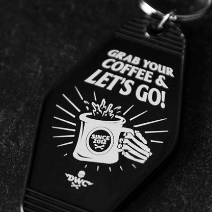A close up of the front of the Death Wish Coffee Coffee, Road Trip, Repeat Keychain.