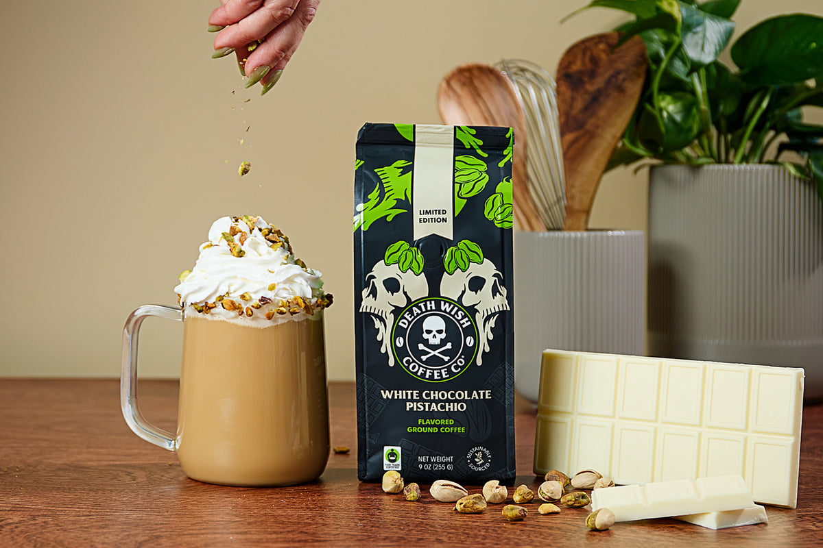 Sprinkling pistachios on top of a White Chocolate Pistachio Coffee.