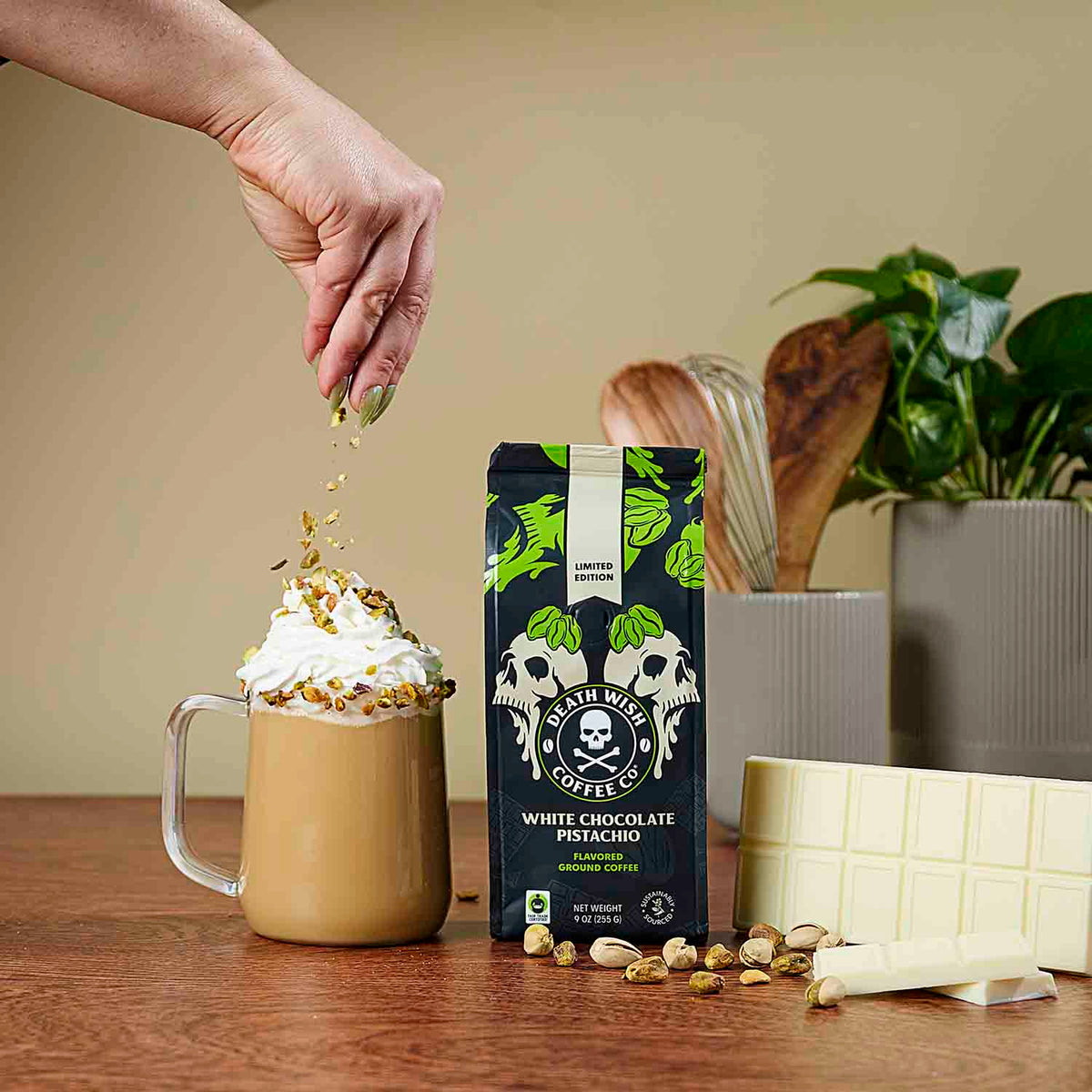 Sprinkling pistachio pieces over a mug of White Chocolate Pistachio Death Wish Coffee.