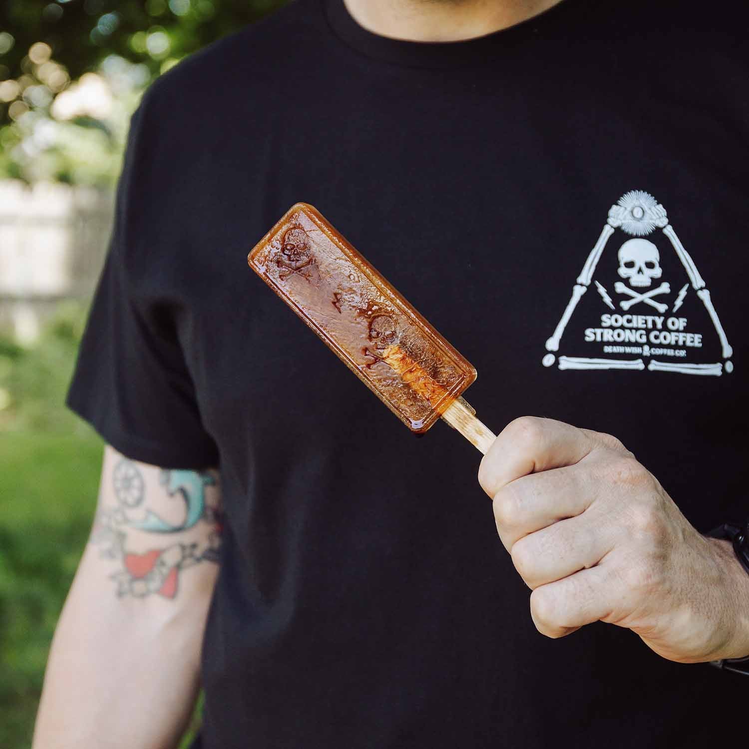A model holding an Iced coffee popsicle made using the Death Wish Coffee Full Strength Ice Pop Molds.