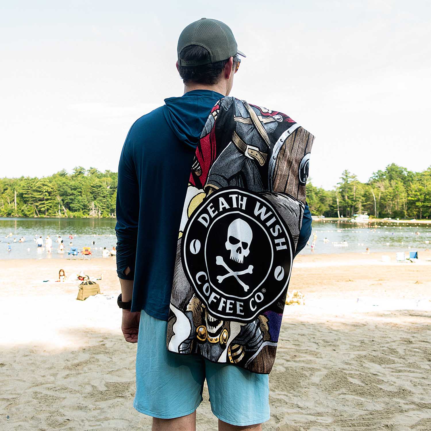 A model carrying the Death Wish Coffee Berserker Beach Towel over his shoulder.