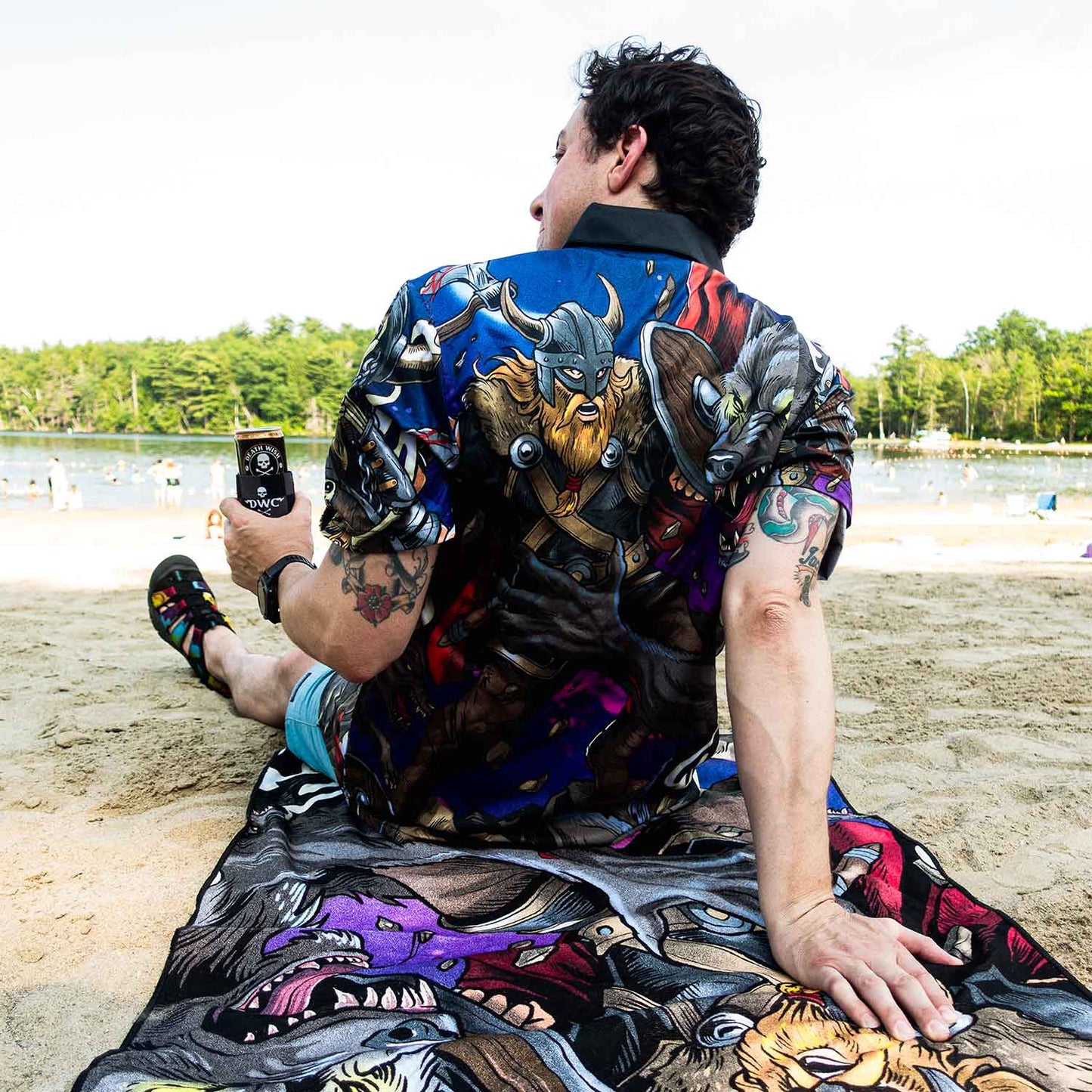 A model wearing the Death Wish Coffee Allfather’s Aloha Button Up and using the matching beach towel.