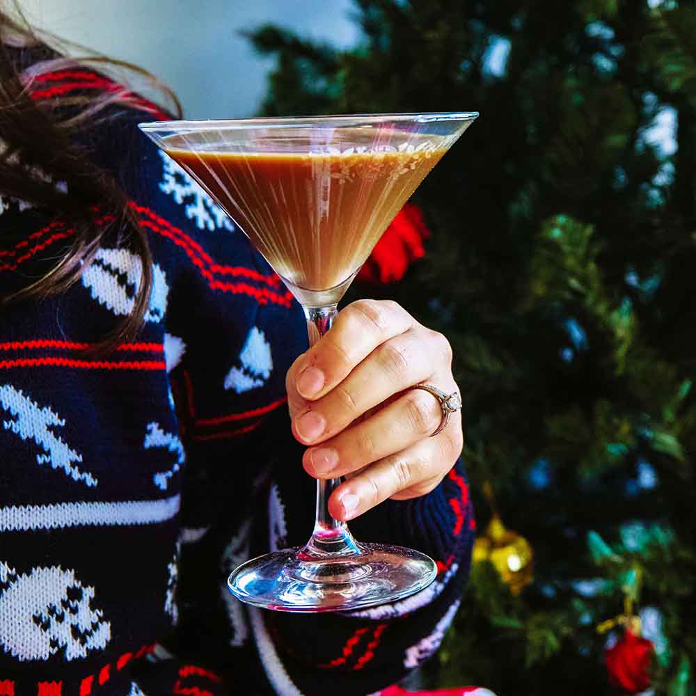 Holding a drink in the Death Wish Coffee Straight Up Martini Glass Set.