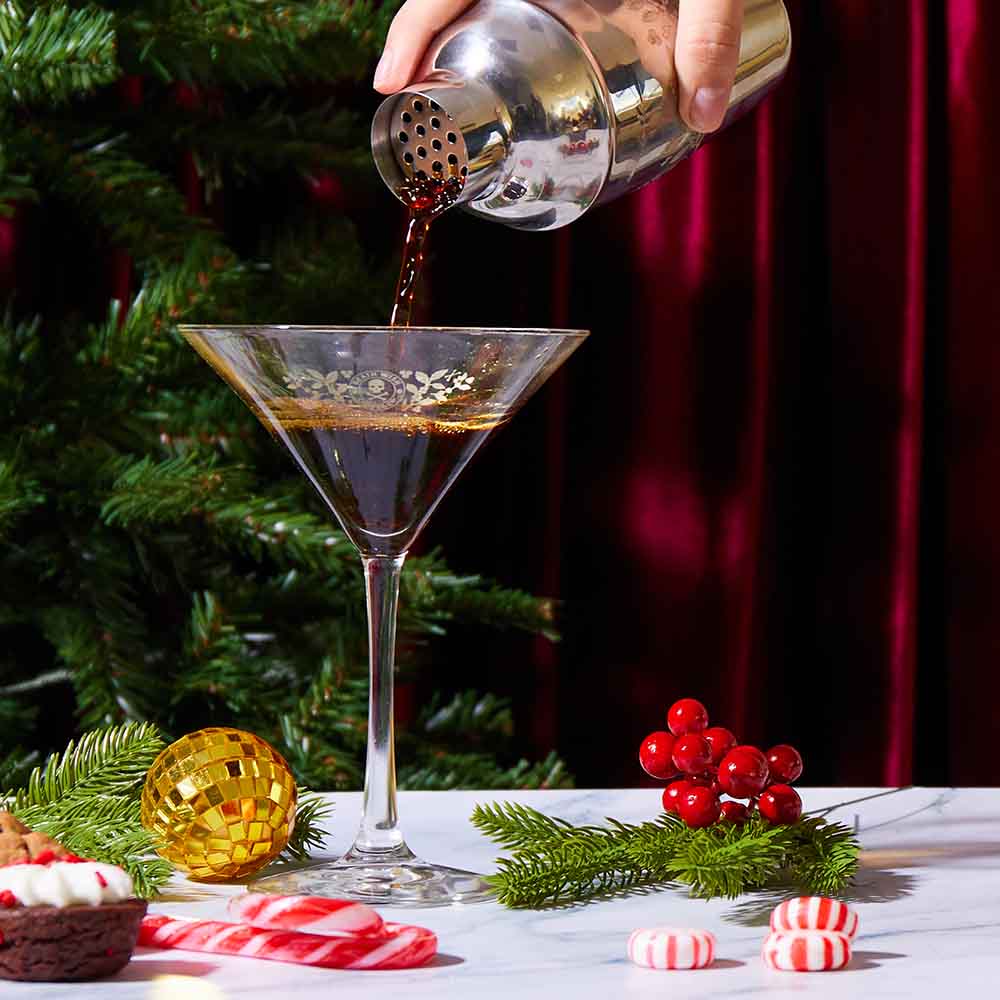 Pouring a drink into the Death Wish Coffee Straight Up Martini Glass Set.